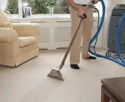 Carpet cleaning professional removing dirt and stains with a hot-water extraction tool in a home, Nashua, NH.