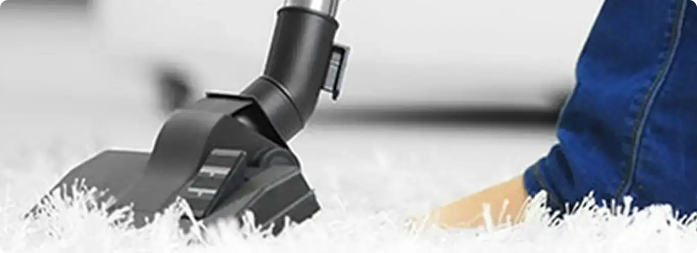 Close-up of a professional vacuuming a white carpet in Pepperell.